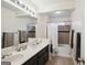 Well-lit bathroom featuring a double vanity with modern fixtures and a tub with tiled surround at 9163 Retreat Pass, Jonesboro, GA 30236