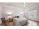 Cozy bedroom features a tray ceiling, ceiling fan, and matching lamps at 9163 Retreat Pass, Jonesboro, GA 30236