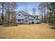 Rear exterior view of a two-story home, showcasing a well-manicured lawn and mature trees at 9163 Retreat Pass, Jonesboro, GA 30236