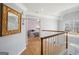 Hallway with wood floors, a wooden banister, and a bedroom view, and decorative mirror at 9163 Retreat Pass, Jonesboro, GA 30236