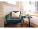 Comfortable reading nook with a green armchair, small table and a window letting in natural light at 2791 Pearl St, East Point, GA 30344