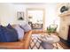 Cozy living room featuring a brick fireplace, leather couch, and stylish rug leading into the dining area at 2791 Pearl St, East Point, GA 30344