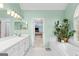 Bright bathroom with dual sinks, a soaking tub, natural light, and a connecting doorway to a bedroom at 220 Terrane Rdg, Peachtree City, GA 30269