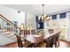 Dining room featuring a large table and chairs, a chandelier, and a view of the staircase and the backyard at 220 Terrane Rdg, Peachtree City, GA 30269
