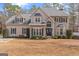 Charming two-story home with a blue front door, black shutters, and a well-manicured lawn in the front yard at 220 Terrane Rdg, Peachtree City, GA 30269