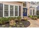 Close-up of a blue front door with wreath, surrounded by lovely landscaping, and large windows with black shutters at 220 Terrane Rdg, Peachtree City, GA 30269