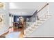 Bright staircase featuring hardwood floors and a glimpse into the adjacent dining room with elegant furniture and decor at 220 Terrane Rdg, Peachtree City, GA 30269