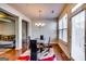 Bright dining room with hardwood floors, modern chandelier, and black dining set with a colorful rug at 2325 Thackery Rd, Snellville, GA 30078