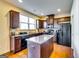 Spacious kitchen showcasing dark wood cabinets, granite counters, a center island, and modern black appliances at 2325 Thackery Rd, Snellville, GA 30078