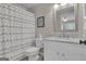 Well-lit bathroom with a wave-patterned shower curtain and white vanity with a granite countertop at 804 Carnellian Ln, Peachtree City, GA 30269