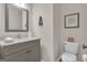 A half bathroom featuring a gray vanity with a granite countertop and decorative wall art at 804 Carnellian Ln, Peachtree City, GA 30269