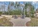 Charming outdoor fire pit surrounded by chairs, nestled in a landscaped backyard with mature trees, perfect for gatherings at 804 Carnellian Ln, Peachtree City, GA 30269