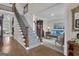 Foyer with hardwood floors, staircase, and adjacent sitting room with neutral carpet and blue sofa at 804 Carnellian Ln, Peachtree City, GA 30269