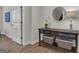 Hallway with white door and table with round mirror, lamp, plants, books, and baskets at 804 Carnellian Ln, Peachtree City, GA 30269