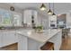 Bright kitchen with a large island, white cabinets, stainless steel sink, and a view to the living space at 804 Carnellian Ln, Peachtree City, GA 30269