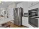 Kitchen with stainless steel refrigerator, built-in ovens, white cabinets, and adjacent breakfast nook at 804 Carnellian Ln, Peachtree City, GA 30269