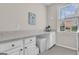 Bright laundry room with quartz counters, white cabinets and space for storage at 804 Carnellian Ln, Peachtree City, GA 30269