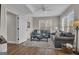 Living room with hardwood floors, a grey couch, multiple windows and neutral paint at 804 Carnellian Ln, Peachtree City, GA 30269