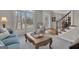 Bright living room featuring neutral carpet, coffered coffee table, and large windows with white shutters at 804 Carnellian Ln, Peachtree City, GA 30269