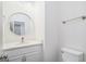 Bright bathroom with round mirror, white vanity, and toilet for a fresh and clean feel at 1320 Kay Se Ter, Conyers, GA 30013