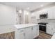 Bright kitchen featuring a center island, white cabinets, stainless steel appliances, and hardwood floors at 1320 Kay Se Ter, Conyers, GA 30013