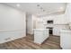 Bright kitchen featuring a center island, white cabinets, stainless steel appliances, and hardwood floors at 1320 Kay Se Ter, Conyers, GA 30013