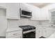 Close-up of the stainless steel gas range and microwave, with modern backsplash and elegant countertops at 1320 Kay Se Ter, Conyers, GA 30013