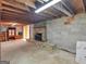 Basement featuring exposed beams, concrete block walls, and a rustic stone fireplace at 6393 Walker Rd, Riverdale, GA 30296