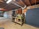 Basement showcasing unfinished walls, exposed wood ceiling, and a sturdy workbench at 6393 Walker Rd, Riverdale, GA 30296