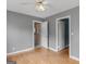 Bedroom has gray walls, hardwood flooring, ceiling fan, and two open doorways at 6393 Walker Rd, Riverdale, GA 30296