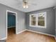 Bedroom features a large window, ceiling fan, gray walls and hardwood flooring at 6393 Walker Rd, Riverdale, GA 30296