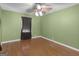 Bedroom showcasing hardwood floors, light green walls, and a ceiling fan at 6393 Walker Rd, Riverdale, GA 30296