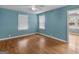 This bedroom has hardwood floors, a ceiling fan, and a large window for ample natural light at 6393 Walker Rd, Riverdale, GA 30296