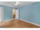 Bedroom featuring a ceiling fan, hardwood floors, a light blue wall, and an open doorway at 6393 Walker Rd, Riverdale, GA 30296