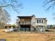 Charming two-story home with a stone chimney, balcony, and yard with mature trees offering a serene outdoor space at 6393 Walker Rd, Riverdale, GA 30296