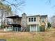 Charming two-story home with a stone chimney, balcony, and yard with mature trees offering a serene outdoor space at 6393 Walker Rd, Riverdale, GA 30296