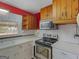 Galley kitchen features classic appliances, plenty of storage, and white countertops at 6393 Walker Rd, Riverdale, GA 30296