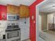 A well-equipped kitchen featuring modern appliances, wooden cabinets, and red accent walls at 6393 Walker Rd, Riverdale, GA 30296