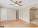 Living room with hardwood floors, neutral walls, ceiling fan, and multiple open doorways at 6393 Walker Rd, Riverdale, GA 30296