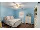 Cozy bedroom with light blue walls, a ceiling fan, and a white bed frame, offering a relaxing space at 302 Cumberland Ct, Peachtree City, GA 30269