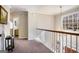 Bright upstairs hallway featuring a decorative chandelier, with a large window that offers a view of the outdoors at 302 Cumberland Ct, Peachtree City, GA 30269