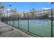Well-maintained tennis court enclosed by a black fence with landscaping at 302 Cumberland Ct, Peachtree City, GA 30269