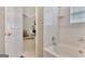 Bathroom with a tub, white tiles, and a doorway view leading into a bedroom with a rocking chair at 498 N Jeff Davis Dr, Fayetteville, GA 30214
