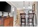 Stylish dining area with bar seating, view into a powder room, and a wooden cabinet at 498 N Jeff Davis Dr, Fayetteville, GA 30214