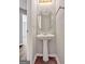 Cozy half bathroom features pedestal sink, an oval mirror, and convenient access for guests at 1915 Grove Way, Hampton, GA 30228