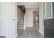Inviting foyer with stylish gray wood-look floors and staircase leading to the upper level at 1915 Grove Way, Hampton, GA 30228