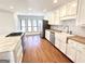 A bright kitchen with white cabinets, butcher block counters, stainless appliances, and hardwood flooring at 304 Chestatee Ct, Woodstock, GA 30188