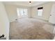 A bright living room with carpeted flooring and an open doorway to a sunroom at 304 Chestatee Ct, Woodstock, GA 30188