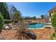 A beautifully landscaped backyard with a pool, pergola, and lush greenery offers a private outdoor retreat at 300 Annelise Park Dr, Fayetteville, GA 30214