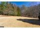 A large backyard features dormant grass and surrounding trees at 300 Annelise Park Dr, Fayetteville, GA 30214